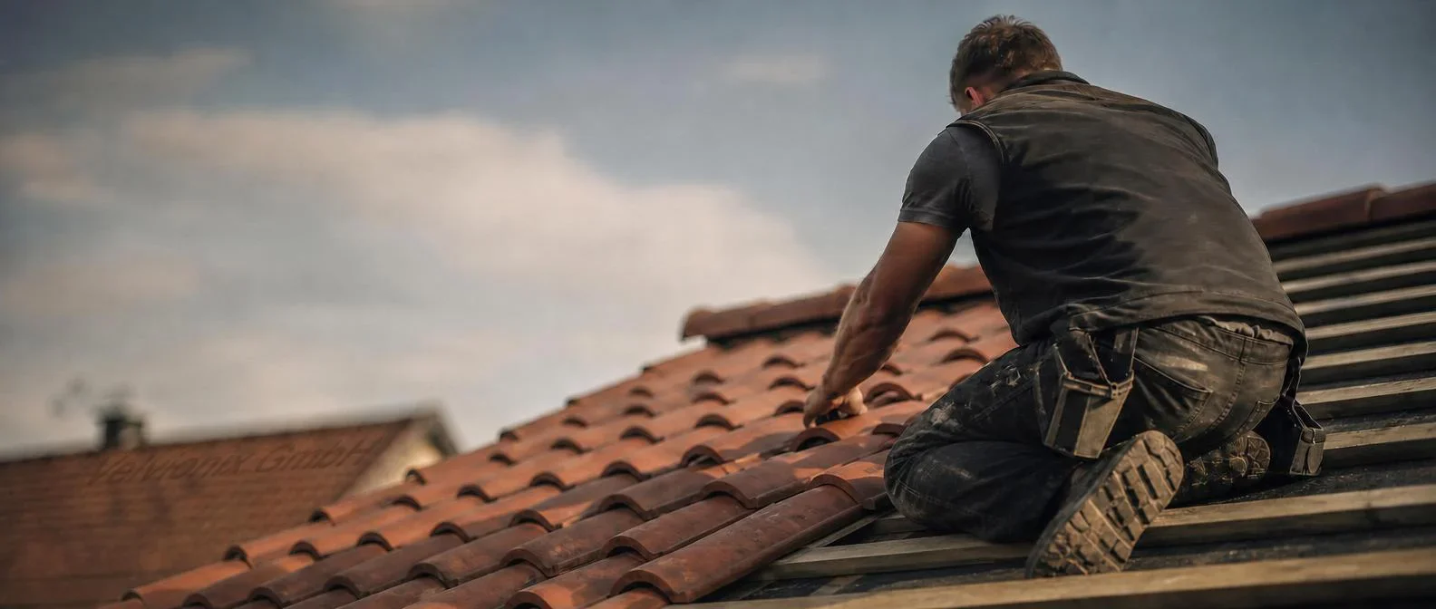 Dekoratives Branchenmotiv: Dachdecker bei der Arbeit auf einem Steildach mit Dachziegeln